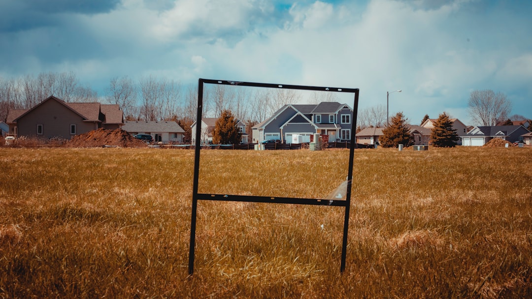 Modern building entrance with glass facade and surrounding greenery.