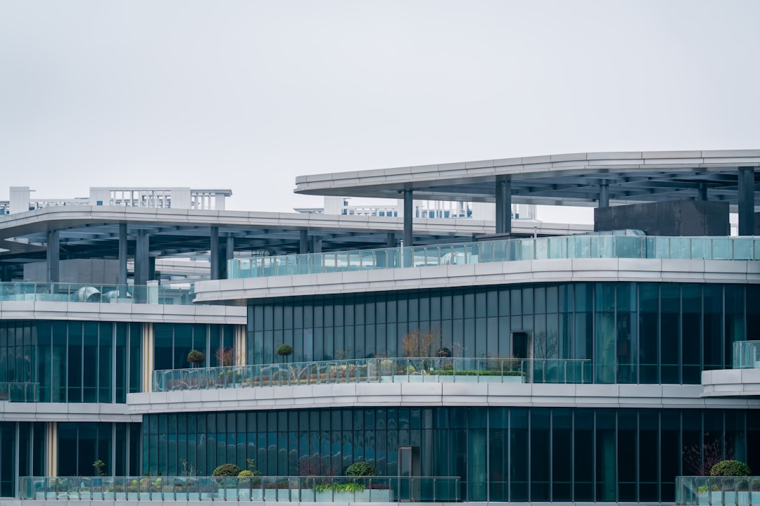 Modern buildings with pools and green spaces near highway.