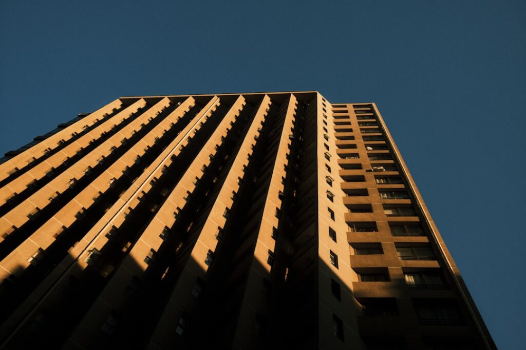 Modern glass building with reflections under cloudy sky
