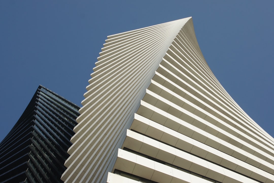 Modern white building with ribbed facade against blue sky